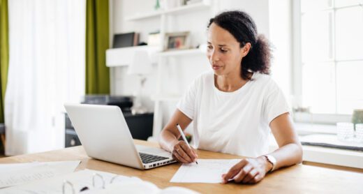 woman taking notes from laptop