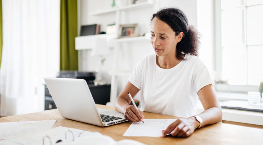 woman taking notes from laptop