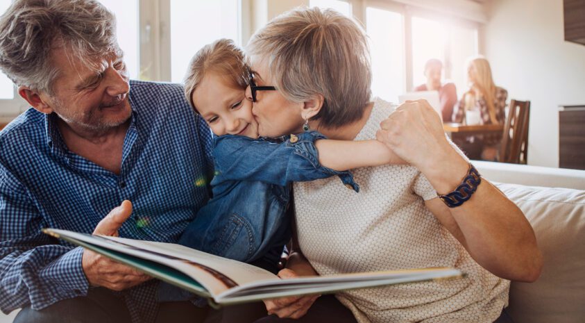 grandparents and granddaughter reading