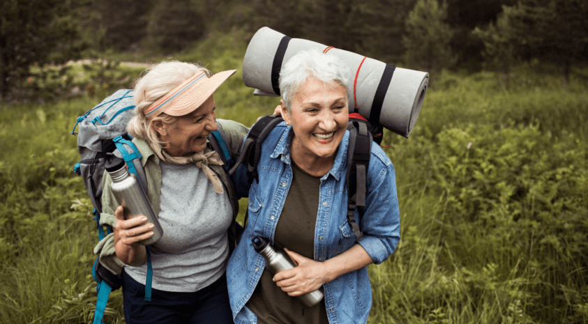 two senior women friends hiking outdoors