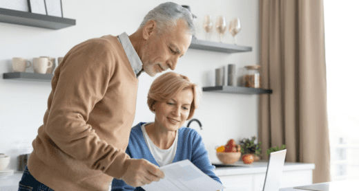 Retiring couple reviewing medical bills at computer