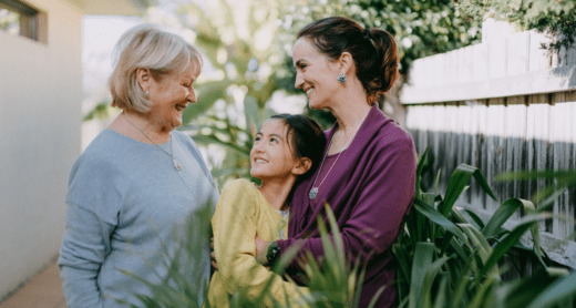 multi generational family with grandmother, mother and daughter in garden