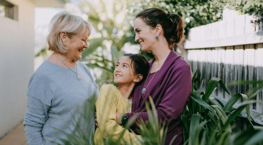 multi generational family with grandmother, mother and daughter in garden