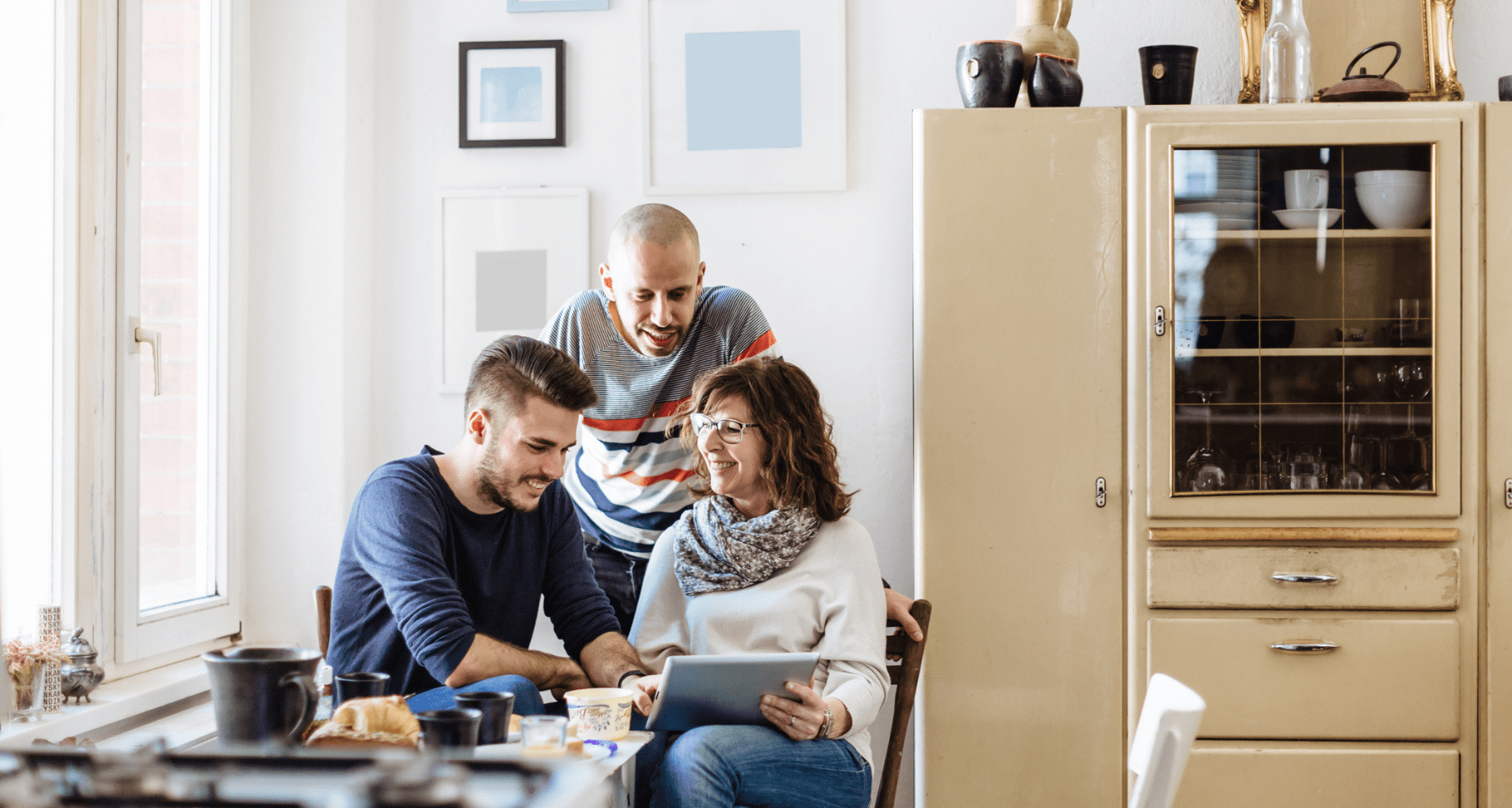 Group of three people discussing financial planning at a table, with a tablet, in a cozy room, emphasizing collaboration and communication about estate management and probate costs.