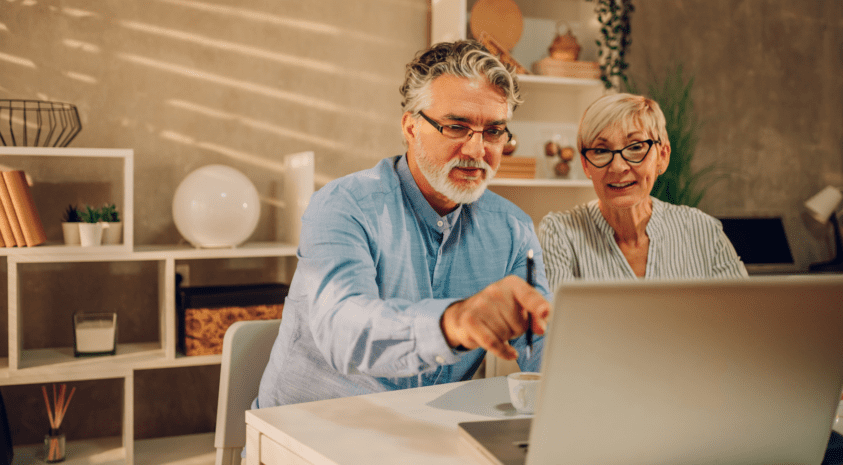 Retired couple reviewing Medicare options are their computer