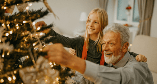 Senior decorating Christmas tree with granddaughter