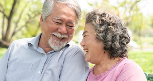 A smiling older couple sitting side by side.