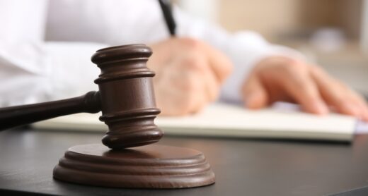 A gavel near a person signing documents.