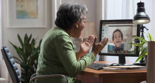 A grandmother video chats with her grandchild on the computer.