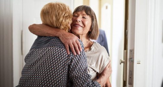 A woman hugs her friend who has Alzheimer's disease.
