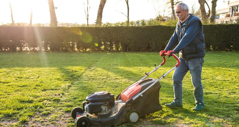 A retiree mows his lawn.