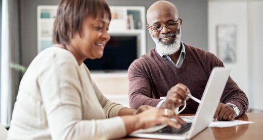 A retired couple discusses their Medicare coverage options at home.