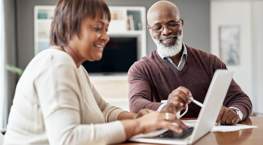 A retired couple discusses their Medicare coverage options at home.