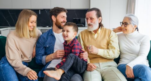 A multigenerational family sits on a couch.