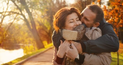 Middle-aged couple embracing in autumn.