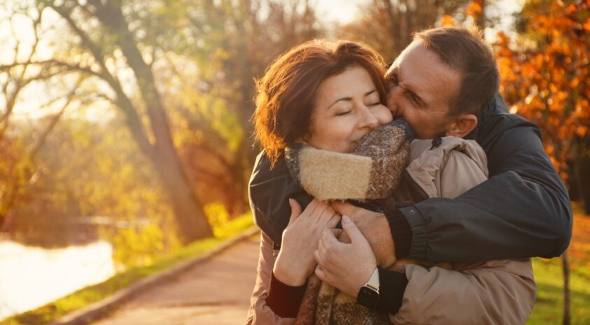 Middle-aged couple embracing in autumn.