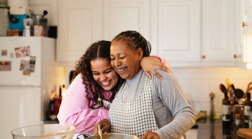 A mother and daughter baking in kitchen.