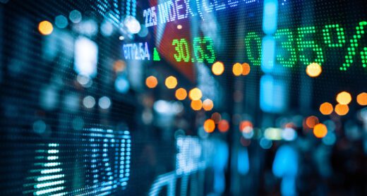 Display of Stock market quotes with city scene reflect on glass.
