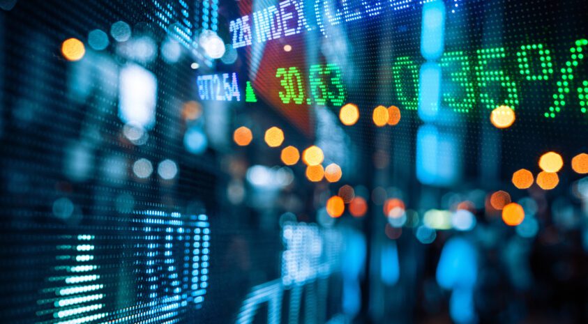 Display of Stock market quotes with city scene reflect on glass.