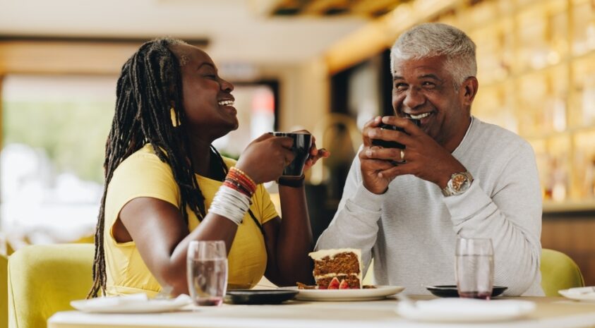 Senior couple laughing over coffee.