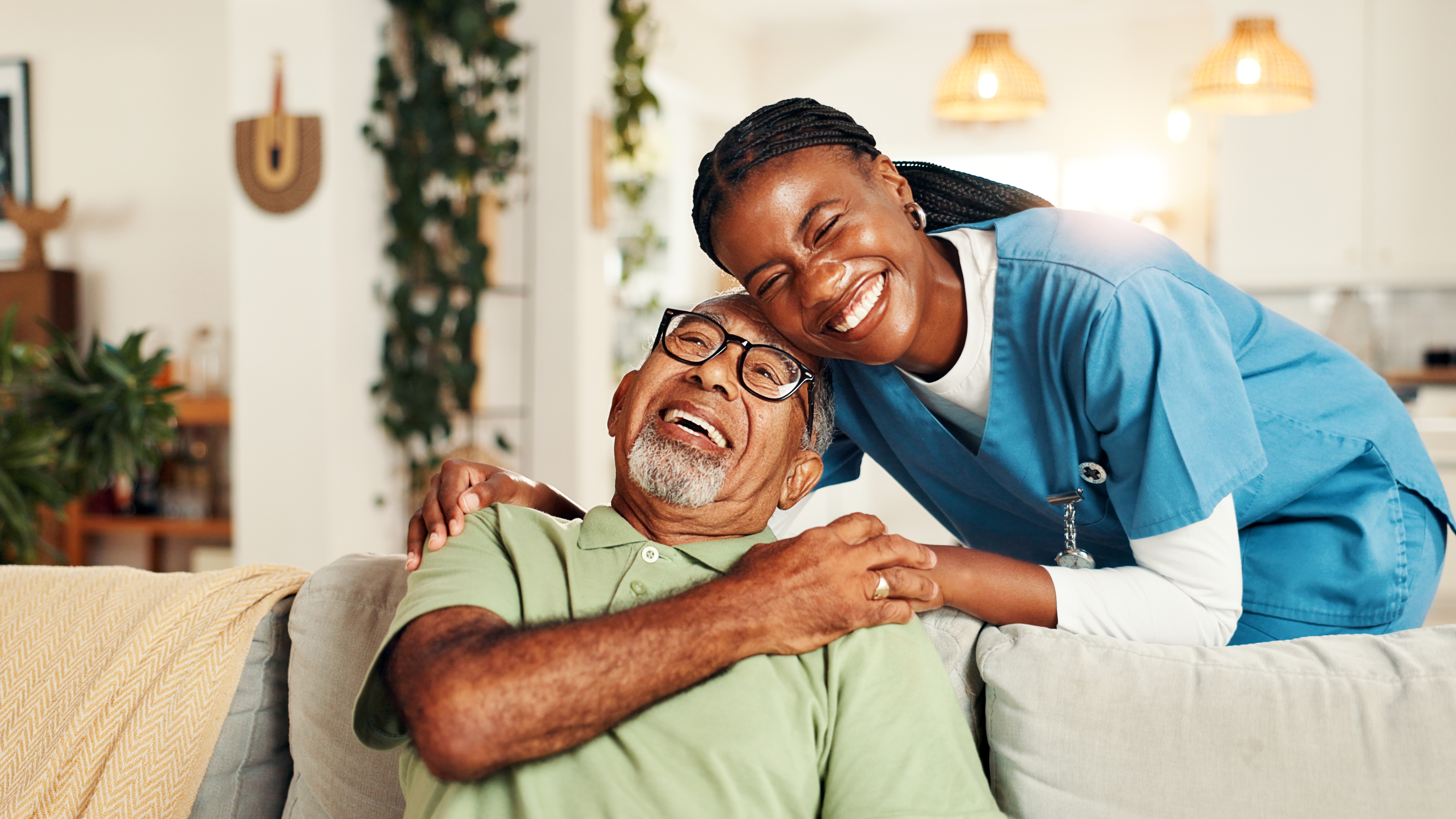 Older adult man with caregiver smiling.