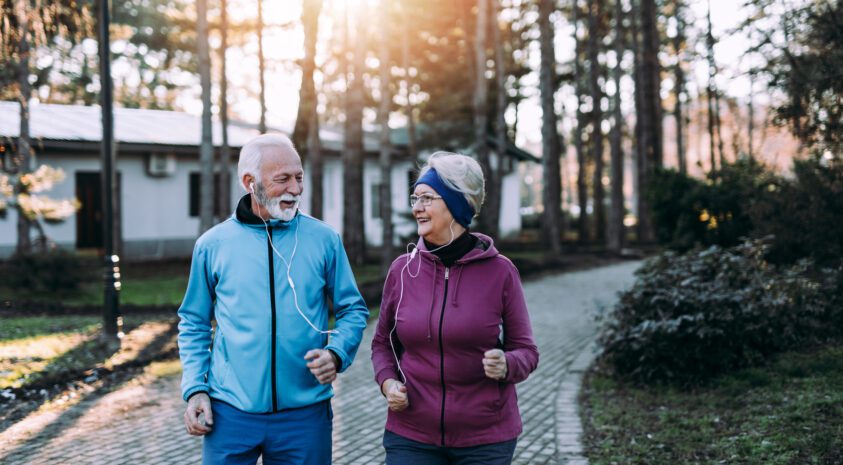 Retired couple enjoys exercising and jogging outdoors on a beautiful sunny day.