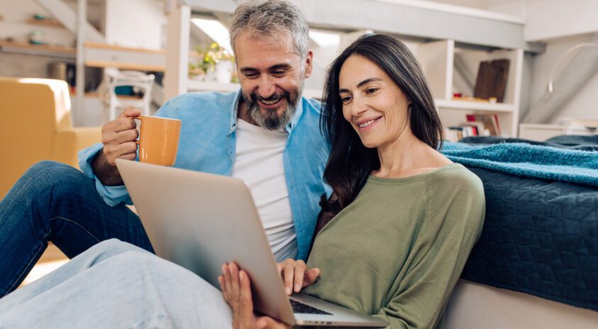 Mature couple working from their living room.