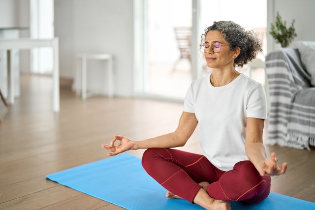 Woman meditating on a yoga mat.