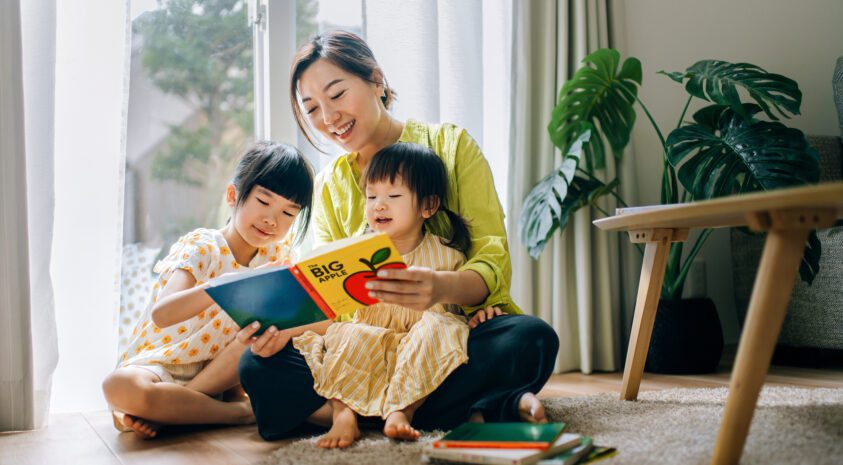 A mother reads a book to her children.