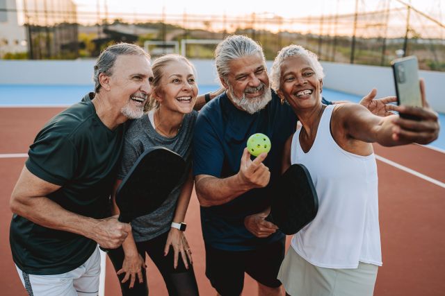 A group of retirees takes a selfie after a game of pickleball.