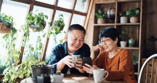 A happy senior couple reviews annuity surrender period options on a smartphone