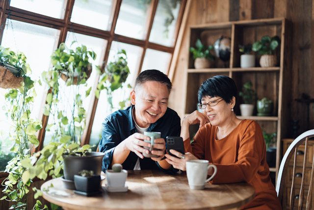 A happy senior couple reviews annuity surrender period options on a smartphone