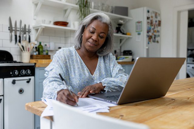 A retired woman reviews annuity payout options on her home computer.