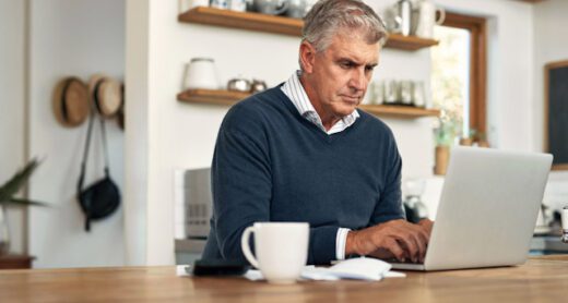 A senior man work on his laptop at home