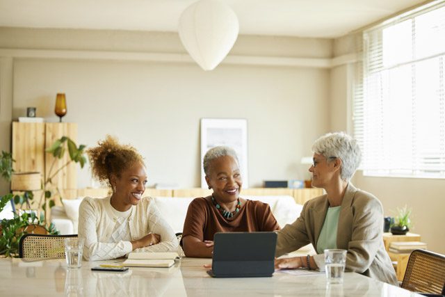 A retired woman and her adult daughter have a conversation with their financial advisor.