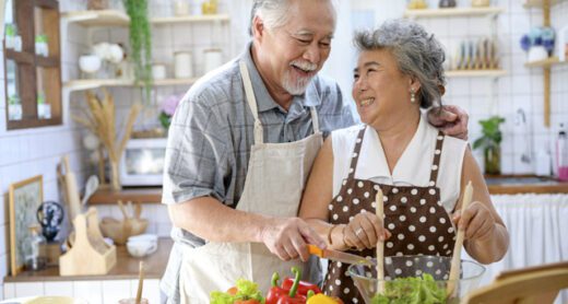 Happy senior couple cooks at home.