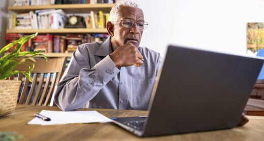 A senior man reviews Medicare coverage on his laptop at home