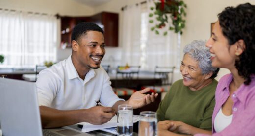 Senior woman and her adult daughter talking to an insurance agent in their home about Medicare Supplement insurance