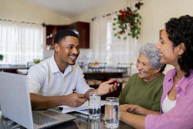Senior woman and her adult daughter talking to an insurance agent in their home about Medicare Supplement insurance